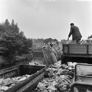 125861 Afbeelding van het storten van huisvuil in vuilnisschuiten in de Biltsche Grift op het Vaaltterrein te Utrecht.